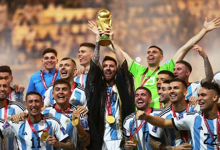 Soccer Football - FIFA World Cup Qatar 2022 - Final - Argentina v France - Lusail Stadium, Lusail, Qatar - December 18, 2022 Argentina's Lionel Messi lifts the World Cup trophy alongside teammates as they celebrate winning the World Cup  REUTERS/Carl Recine