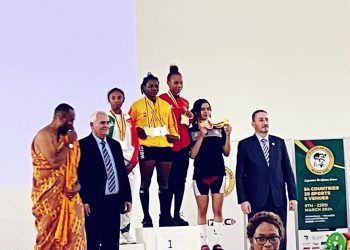 Ntumi stands atop podium after her gold medal winning performance in weightlifting