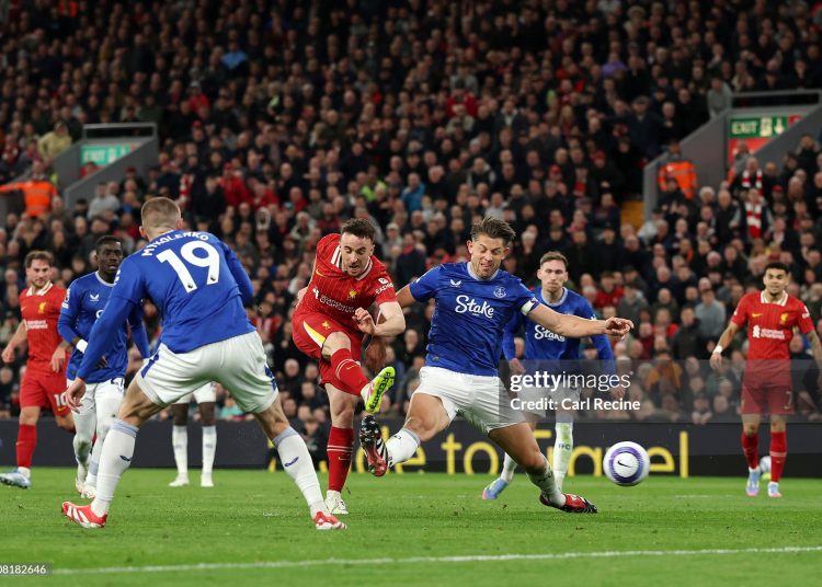 Diogo Jota of Liverpool scores his team's first goal under pressure from James Tarkowski of Everton (Photo by Carl Recine/Getty Images)