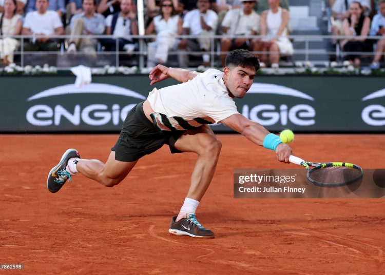 Carlos Alcaraz of Spain stretches to play a backhand against Damir Dzumhur of Bosnia and Herzegovnia (Photo by Julian Finney/Getty Images)