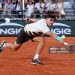 Carlos Alcaraz of Spain stretches to play a backhand against Damir Dzumhur of Bosnia and Herzegovnia (Photo by Julian Finney/Getty Images)