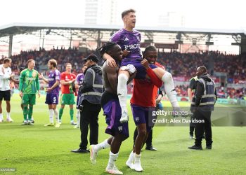 Tom Cairney is lifted by Calvin Bassey and Alex Iwobi as they celebrate victory following the Premier League match between Brentford FC and Fulham FC (Photo by Alex Davidson/Getty Images)