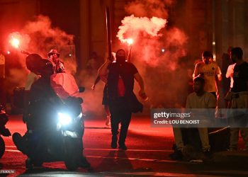 Paris Saint-Germain (PSG) supporters gather holding flares on a street in Paris early June 1, 2025, during celebrations following their 5-0 victory (Photo by LOU BENOIST/AFP via Getty Images)