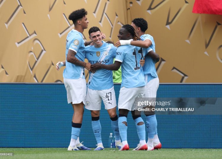 Manchester City's English midfielder #47 Phil Foden (C) is congratulated by teammates after scoring the opening goal during the FIFA Club World Cup 2025 Group G football match between England's Manchester City and Morocco's Wydad AC (Photo by CHARLY TRIBALLEAU/AFP via Getty Images)