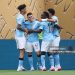 Manchester City's English midfielder #47 Phil Foden (C) is congratulated by teammates after scoring the opening goal during the FIFA Club World Cup 2025 Group G football match between England's Manchester City and Morocco's Wydad AC (Photo by CHARLY TRIBALLEAU/AFP via Getty Images)