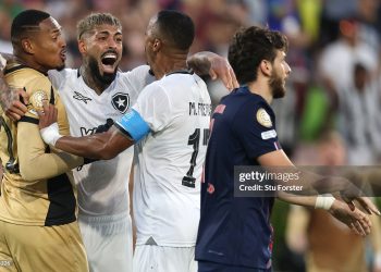 John #12, Alexander Barboza #20, and Marlon Freitas #17 of Botafogo celebrate following the team's victory as Khvicha Kvaratskhelia #7 of Paris Saint-Germain looks on the FIFA Club World Cup 2025 (Photo by Stu Forster/Getty Images)
