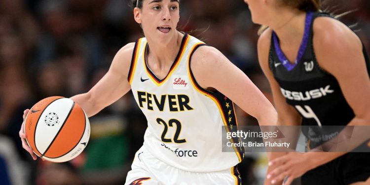 Caitlin Clark #22 of the Indiana Fever drives to the basket against Jacy Sheldon #4 of the Connecticut Sun (Photo by Brian Fluharty/Getty Images)