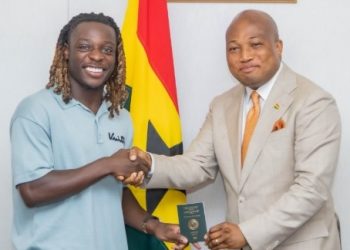 Jeremy Doku (left) receives Ghanaian passport from Ghana's Foreign Affairs Minister Samuel Okudzeto Ablakwa