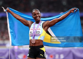 Bronze medalist, Julien Alfred of Team Saint Lucia poses for a photo with the national flag after competing in the Women's 100 Metres Final (Photo by Julian Finney/Getty Images)