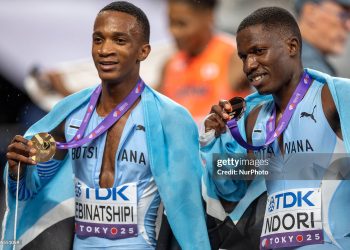 Bronze medalist Bayapo Ndori of Team Botswana (R) and gold medalist Busang Collen Kebinatshipi of Team Botswana (L) pose for a photo with the national flag of Botswana after competing in the Men's 400 Metres Final (Photo by Andrzej Iwanczuk/NurPhoto via Getty Images)
