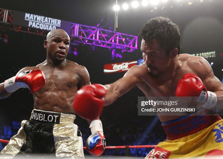 Floyd Mayweather Jr. exchange punches with Manny Pacquiao (Photo credit: JOHN GURZINSKI/AFP via Getty Images)