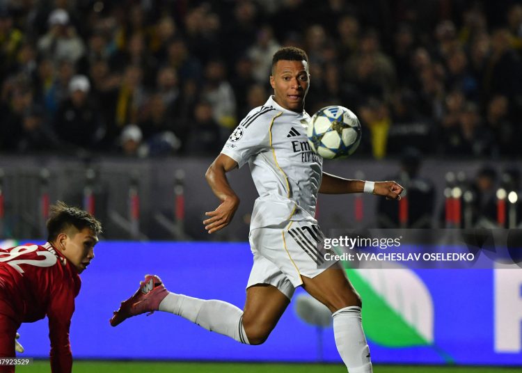 Real Madrid's French forward #10 Kylian Mbappe (R) scores his team's second goal past Kairat Almaty's Kazakh goalkeeper #82 Sherhan Kalmurza (L) during the UEFA Champions League first round day 2 football match between Kairat Almaty and Real Madrid at the Almaty Ortalyk stadion in Almaty on September 30, 2025. (Photo by Vyacheslav OSELEDKO / AFP) (Photo by VYACHESLAV OSELEDKO/AFP via Getty Images)