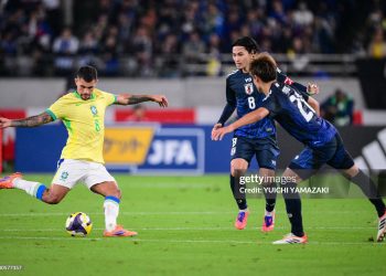 Brazil's midfielder Bruno Guimaraes (L) kicks the ball during the international football friendly match between Japan and Brazil (Photo by YUICHI YAMAZAKI/AFP via Getty Images)