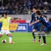 Brazil's midfielder Bruno Guimaraes (L) kicks the ball during the international football friendly match between Japan and Brazil (Photo by YUICHI YAMAZAKI/AFP via Getty Images)