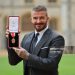 Sir David Beckham poses with his medal after receiving his knighthood for services to sport and charity at Windsor Castle (Photo by Richard Pohle - Pool/Getty Images)
