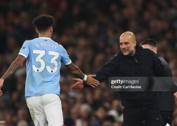 Pep Guardiola, Manager of Manchester City, high fives Nico O'Reilly of Manchester City after he scored his team's third goal during the Premier League match between Manchester City and Bournemouth (Photo by Carl Recine/Getty Images)