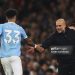 Pep Guardiola, Manager of Manchester City, high fives Nico O'Reilly of Manchester City after he scored his team's third goal during the Premier League match between Manchester City and Bournemouth (Photo by Carl Recine/Getty Images)