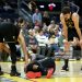 Jimmy Butler III #10 of the Golden State Warriors is looked at by Stephen Curry #30 and Quinten Post #21 after he collided with Davion Mitchell #45 of the Miami Heat and injured his knee during the third quarter (Photo by Ezra Shaw/Getty Images)