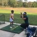 Daniel List showing a child how swing