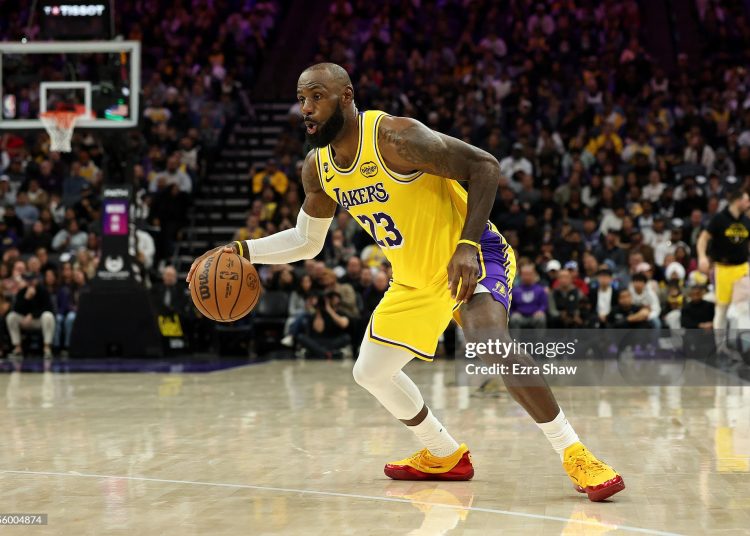 LeBron James #23 of the Los Angeles Lakers dribbles the ball during their game against the Sacramento Kings at Golden 1 Center on January 12, 2026 in Sacramento, California. James is wearing a patch to celebrate his 23rd NBA season (Photo by Ezra Shaw/Getty Images)