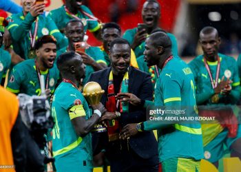 Senegal's head coach Pape Thiaw (C) and the team celebrate with the trophy after winning the Africa Cup of Nations (CAN) final football match against Morocco (Photo by Abdel Majid BZIOUAT / AFP via Getty Images)