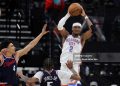 Shai Gilgeous-Alexander #2 of the Oklahoma City Thunder passes the ball over Kobe Sanders #4 and Derrick Jones Jr. #5 of the Los Angeles Clippers during the first half of an NBA game (Photo by Ryan Sirius Sun/Getty Images)