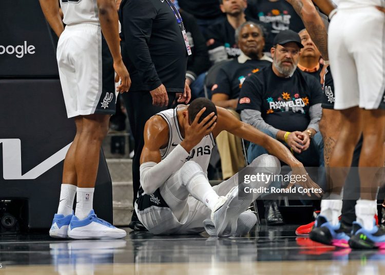 Victor Wembanyama #1 of the San Antonio Spurs holds his head after falling to the court against the Portland Trailblazers in the first half  of Game Two of the Western Conference First Round NBA Playoffs (Photo by Ronald Cortes/Getty Images)
