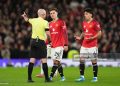 Referee Paul Tierney sends off Manchester United's Lisandro Martinez (right) during the Premier League match (Photo by Martin Rickett/PA Images via Getty Images)