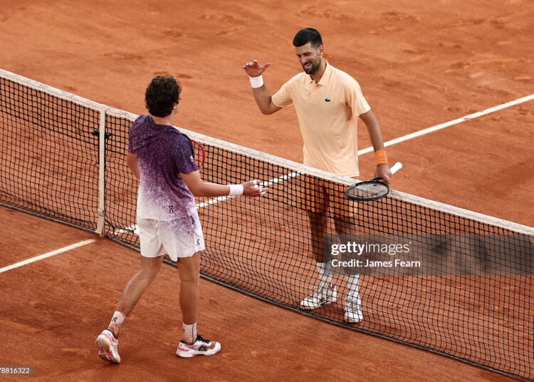 Joao Fonseca of Brazil and Novak Djokovic of Serbia interact at the net following their Men's Singles third round match on Day Six of the 2026 French Open (Photo by James Fearn/Getty Images)