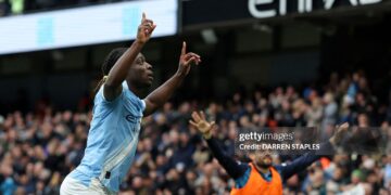 Manchester City's Belgian midfielder #11 Jeremy Doku (L) celebrates after scoring the opening goal during the English Premier League football match between Manchester City and Brentford (Photo by Darren Staples / AFP via Getty Images)