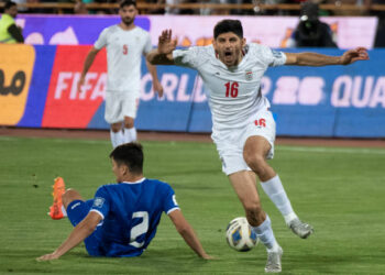 Iran's Mahdi Torabi (16) is reacting while Uzbekistan's Abdukodir Khusanov (2) is lying on the pitch during the FIFA World Cup 26 AFC qualifying round two group E soccer match at the Azadi (Freedom) Stadium in Tehran, Iran, on June 11, 2024. (Photo by Morteza Nikoubazl/NurPhoto via Getty Images)