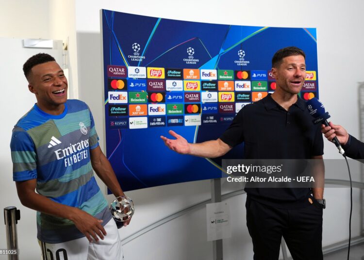 Xabi Alonso, Head Coach of Real Madrid, reacts alongside Kylian Mbappe of Real Madrid as he speaks to the media after the team's victory in the UEFA Champions League 2025/26 League Phase MD1 match between Real Madrid C.F. and Olympique de Marseille (Photo by Aitor Alcalde - UEFA/UEFA via Getty Images)