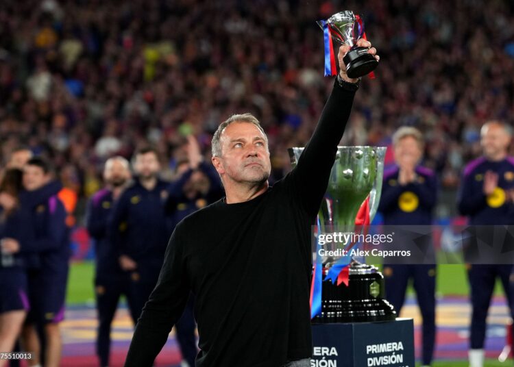 Hansi Flick, Head Coach of FC Barcelona, lifts a miniature of the LaLiga EA Sports trophy as he celebrates after defeating Real Madrid, and winning the LaLiga title, after the LaLiga EA Sports match between FC Barcelona and Real Madrid CF (Photo by Alex Caparros/Getty Images)