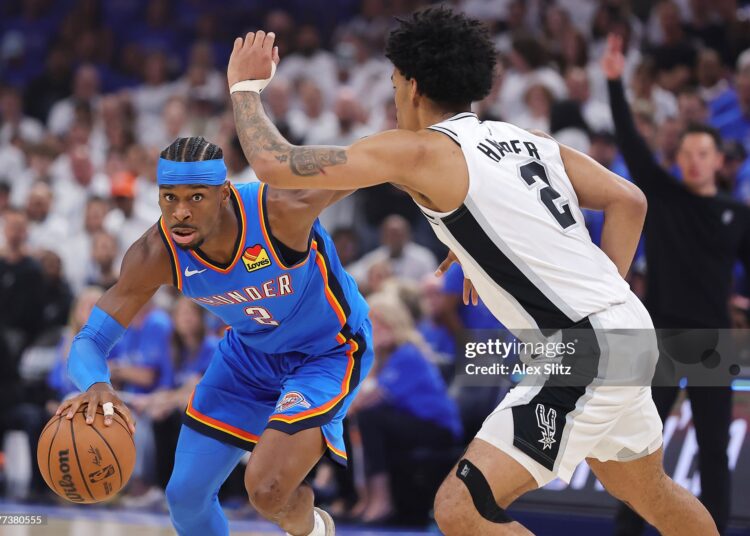 Shai Gilgeous-Alexander #2 of the Oklahoma City Thunder drives around Dylan Harper #2 of the San Antonio Spurs during the first quarter in Game Two of the NBA Western Conference Finals (Photo by Alex Slitz/Getty Images)
