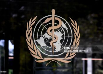 This photograph shows the logo of the World Health Organization (WHO) on the entrance of their headquarters ahead of the 79th World Health Assembly in Geneva, on May 17, 2026. (Photo by Fabrice COFFRINI / AFP via Getty Images)