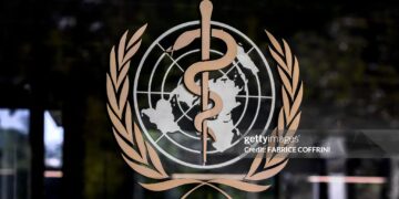 This photograph shows the logo of the World Health Organization (WHO) on the entrance of their headquarters ahead of the 79th World Health Assembly in Geneva, on May 17, 2026. (Photo by Fabrice COFFRINI / AFP via Getty Images)