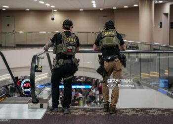 Law enforcement agents as travelers wait in line to be screened at a Transportation Security Administration (TSA) checkpoint at Hartsfield-Jackson Atlanta International Airport (ATL) Photographer: Elijah Nouvelage/Bloomberg via Getty Images