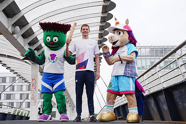 Swimmer Duncan Scott poses with mascots Clyde (left) and Finnie (right) on Bell's Bridge after his journey up the River Clyde in Glasgow for the official launch of the Scotland leg of the King's Baton Relay. The baton will travel from the Team Scotland camp in Glasgow to more than 50 events across the country, celebrating Scottish sport, culture, the Commonwealth and the Games. Picture date: Wednesday July 1, 2026. (Photo by Jane Barlow/PA Images via Getty Images)