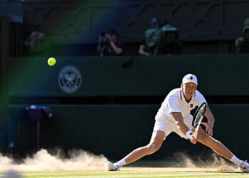 Italy's Jannik Sinner slips on the ground as he returns to Germany's Alexander Zverev during their men's singles final tennis match on the fourteenth day of the 2026 Wimbledon Championships at The All England Lawn Tennis and Croquet Club in Wimbledon, southwest London, on July 12, 2026. (Photo by Kirill KUDRYAVTSEV / AFP via Getty Images) / RESTRICTED TO EDITORIAL USE