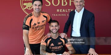 Bruno Guimaraes signs for Arsenal alongside Manager Mikel Arteta and Arsenal Sporting Director Andrea Berta (Photo by David Price/Arsenal FC via Getty Images)