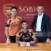 Bruno Guimaraes signs for Arsenal alongside Manager Mikel Arteta and Arsenal Sporting Director Andrea Berta (Photo by David Price/Arsenal FC via Getty Images)