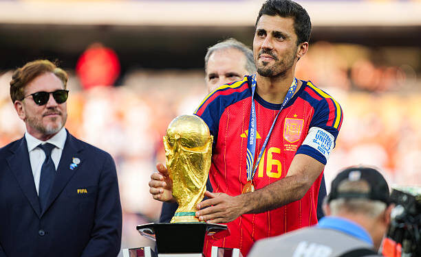 Rodri #9 of Spain picks up the FIFA World Cup Winner’s Trophy after defeating Argentina in the FIFA World Cup 2026 Final at New York New Jersey Stadium on July 19, 2026 in East Rutherford, New Jersey. Spain defeated reigning World Cup champions Argentina, who were led by Lionel Messi, with the lone goal coming from Ferran Torres #7 in the 106th minute of extra time. (Photo by Andrew Harnik/Getty Images)