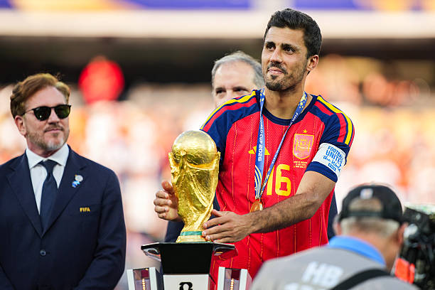 Rodri #9 of Spain picks up the FIFA World Cup Winner’s Trophy after defeating Argentina in the FIFA World Cup 2026 Final at New York New Jersey Stadium on July 19, 2026 in East Rutherford, New Jersey. Spain defeated reigning World Cup champions Argentina, who were led by Lionel Messi, with the lone goal coming from Ferran Torres #7 in the 106th minute of extra time. (Photo by Andrew Harnik/Getty Images)
