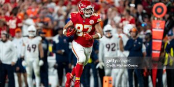 Travis Kelce #87 of the Kansas City Chiefs runs with the ball against the Denver Broncos during an NFL football game (Photo by Michael Owens/Getty Images)