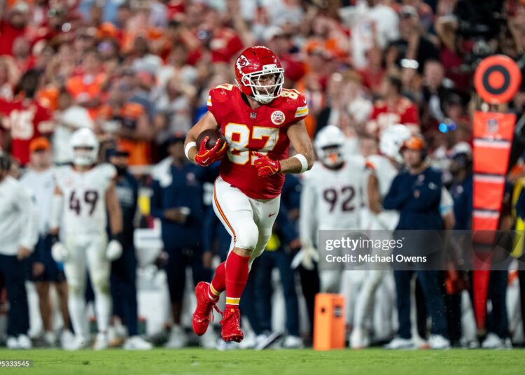 Travis Kelce #87 of the Kansas City Chiefs runs with the ball against the Denver Broncos during an NFL football game (Photo by Michael Owens/Getty Images)