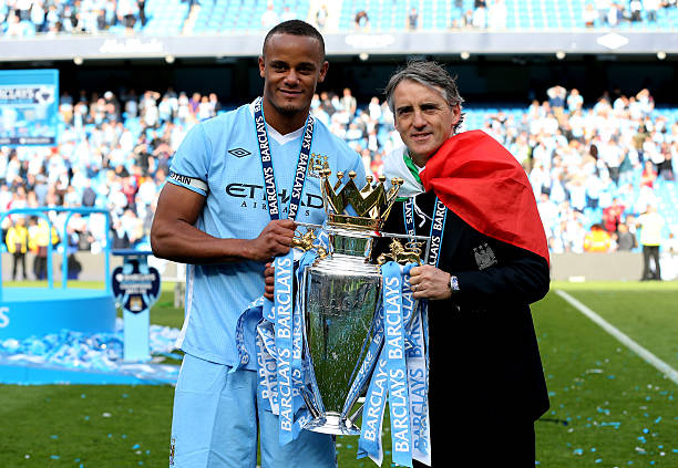 Vincent Kompany the captain of Manchester City and Roberto Mancini the manager of Manchester City pose with the trophy following the Barclays Premier League match between Manchester City and Queens Park Rangers at the Etihad Stadium on May 13, 2012 in Manchester, England. (Photo by Alex Livesey/Getty Images)